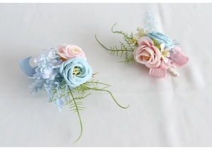 Detail of pink and blue silk wedding corsages with artificial roses and ribbon