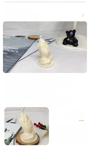 Detailed view of prayer hand scented candle with packaging and premium soy wax texture