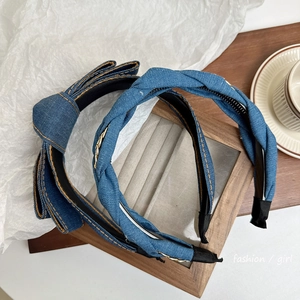 Denim fabric headbands with bow and chain knot design on a wooden tray background