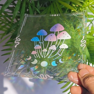 Close-up of holographic suncatcher sticker featuring mushroom and moon phases patterns