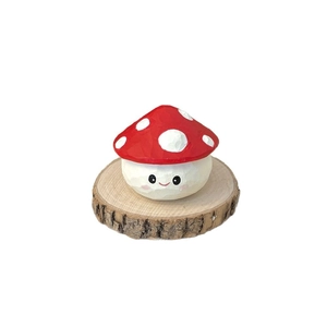 Handcrafted wooden mushroom figurine with red polka dot cap on a natural wood base