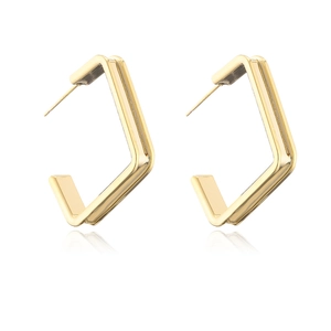 Macro view showing the polished gold finish of geometric C-shaped hoop earrings