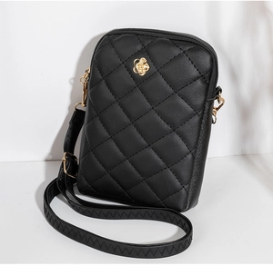 Detailed side view of black quilted crossbody phone bag with gold floral hardware
