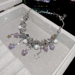 Détail du bracelet argenté avec perles, papillons et breloques étoiles dans un coffret