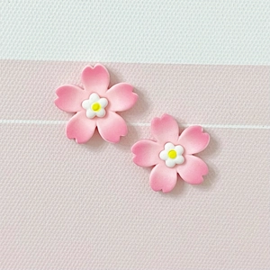 Detail of pink resin cherry blossom charms with white cores for DIY crafts and hair accessories