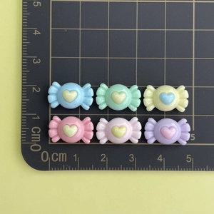 Mini resin candy charms for DIY crafts shown on scale ruler with colorful heart detail