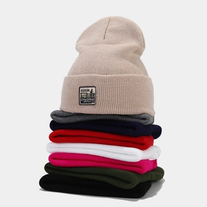 Stacked ribbed knit beanies in multiple colors with vintage denim supply logo patch