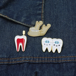 Detailed close-up of cartoon dental pins pinned on dark blue denim fabric