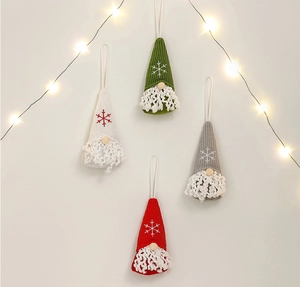 Close-up of four knitted Christmas gnomes with snowflake embroidery and LED light decor