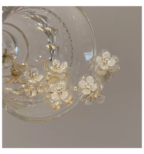 Detailed view of mini camellia hair claw with rhinestone on glass rim