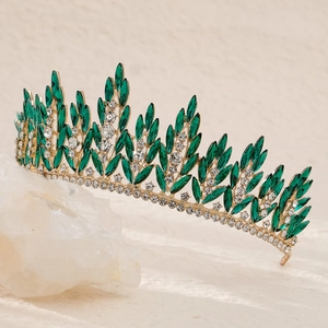 Close-up of a gold bridal crown with green marquise stones and sparkling crystals