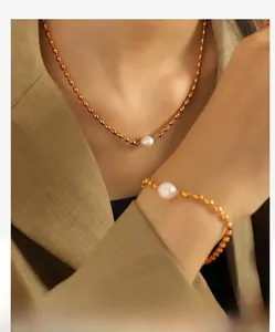 Detail of elegant gold pearl jewelry set worn by a model on a khaki textured background