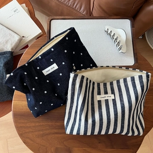 Retro canvas toiletry bags with polka dot and striped patterns on a wooden table