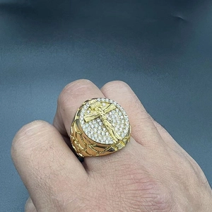Detail of gold hip-hop ring with crucifix relief and micro-pave cubic zirconia