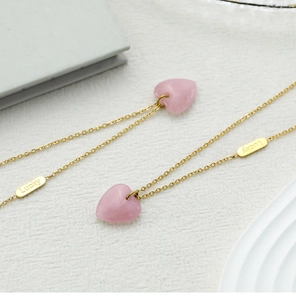 Detail of pink crystal heart pendant with gold Lucky tag on a polished chain