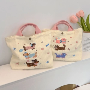 Gros plan de sacs fourre-tout en velours côtelé avec broderies d'animaux mignons