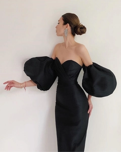 Detail of elegant black off-shoulder dress featuring dramatic lantern sleeves and silk texture