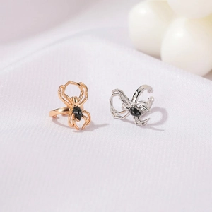 Macro shot of punk spider ear cuffs in gold and silver finish with black stone accents