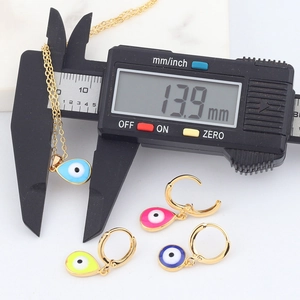 Macro view of 13.9 mm Evil Eye pendant being measured with a digital caliper tool