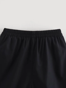Détail de la taille élastique noire sur un pantalon avec texture de tissu plissé