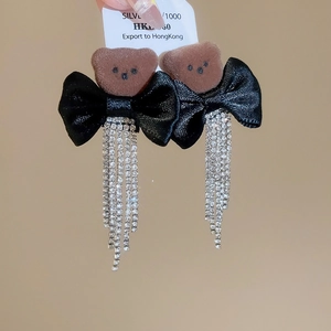Detail of brown flocked bear earrings with black satin bow and sparkling rhinestone tassels