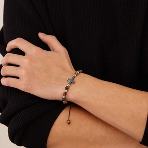 Primo piano di un bracciale da uomo con pietre occhio di tigre naturali e ciondolo a croce