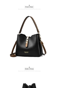 Detail of black tote bag with brown straps, gold hardware and visible leather texture
