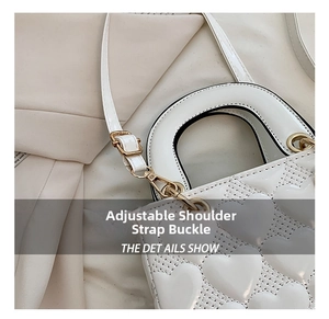 Detailed close-up of golden adjustment buckle on white heart-quilted bridal handbag