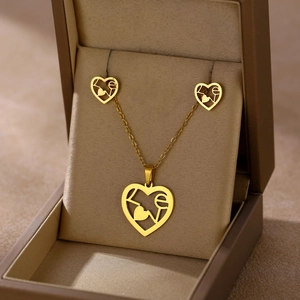 Close-up of golden heart jewelry set with LOVE lettering in a brown gift box