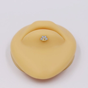 Macro view of gold cat paw labret stud featuring four blue opal stones on silicone model