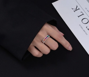 Gros plan d'une bague en argent ornée de zircons rectangulaires aux couleurs de l'arc-en-ciel