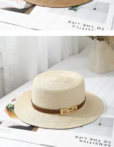 Detail of high-quality woven straw boater hat with brown leather band and gold buckle