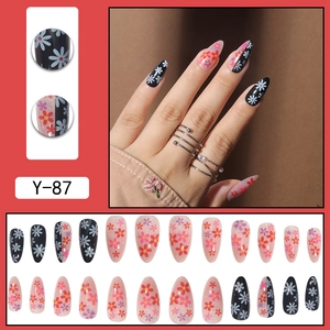 Almond shaped press-on nails with floral daisy patterns in pink and black shades