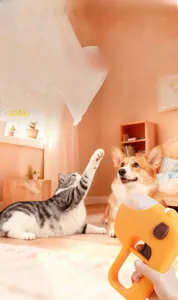 Orange pet food launcher toy gun with transparent storage bin for cat and dog interaction