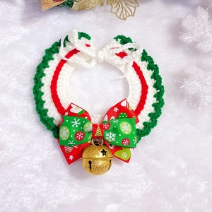 Detail of hand-knitted Christmas pet collar with bow and golden star bell ornament