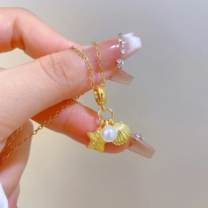 Titanium steel necklace with shell, star, and pearl charms held by hand