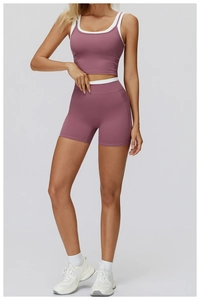Vue de face de l'ensemble de yoga rose poudré et blanc avec short et brassière