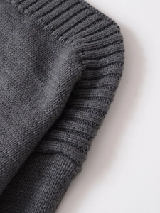 Vista macro dettagliata della trama a maglia a coste grigio scuro su un maglione in maglia
