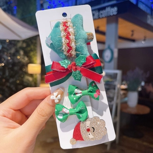 Detailed Christmas hair clips set with reindeer, tree and bow on a white card display