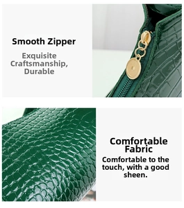 Detail of dark green crocodile texture bag with smooth golden metal zipper and stitching