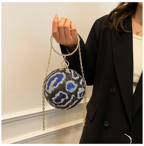 Macro shot of spherical evening bag featuring leopard sequin pattern and rhinestone handle
