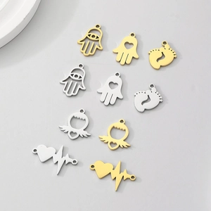 Detailed flat lay of stainless steel charms in gold and silver showing symbolic shapes