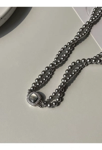 Macro detail of double-layer grey pearl necklace with square zircon shell clasp