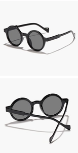 Detailed views of vintage round black sunglasses featuring high-gloss resin frames