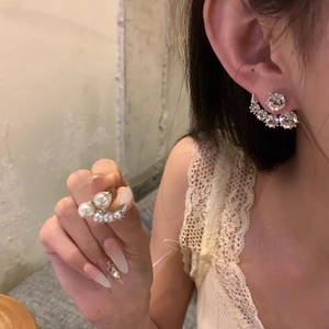 Elegant silver needle horn earrings with pearls and rhinestones shown on a model