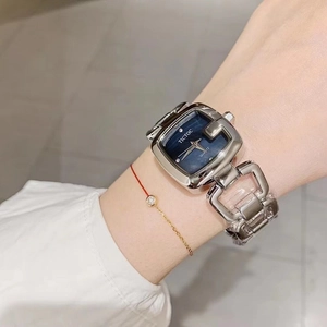 Detail of silver square watch with deep blue dial and unique horsebit link bracelet