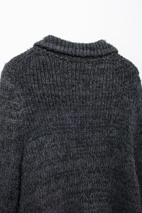 Gros plan détaillé du pull en maille épaisse gris foncé montrant le col et la texture