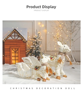 Close-up of white plush reindeer family and gold sleigh Christmas window display set