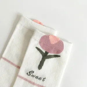 Detail of white cotton sock with tulip floral pattern and elastic ribbed cuff texture