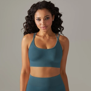 Detail of seamless teal blue sports bra featuring cross-back straps and ribbed texture